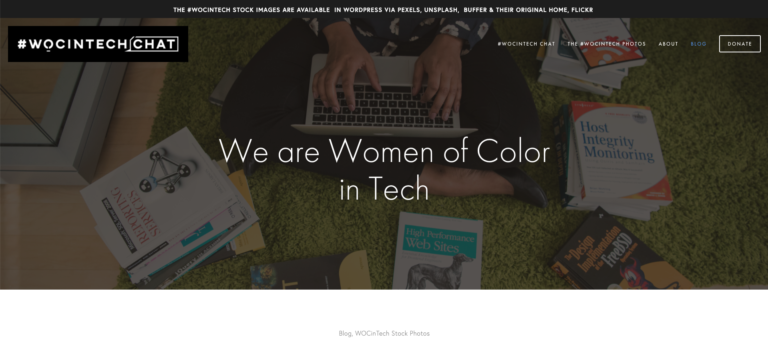 Woman using laptop surrounded by technical books, representing women of color in technology and searching the best sites for free images.